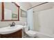 Well-lit bathroom featuring a wood vanity, sink, toilet, and bathtub with shower, creating a functional and inviting space at 9385 Prairie View Dr, Highlands Ranch, CO 80126