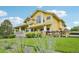 Charming yellow two-story home featuring a welcoming front porch and well-manicured lawn with garden at 9385 Prairie View Dr, Highlands Ranch, CO 80126