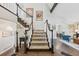 Elegant foyer featuring hardwood floors, a staircase with white railings, and artwork enhancing the inviting atmosphere at 9385 Prairie View Dr, Highlands Ranch, CO 80126