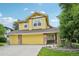 Spacious yellow three-car garage with stone accents and inviting entryway with decorative columns at 9385 Prairie View Dr, Highlands Ranch, CO 80126