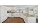 Stylish kitchen featuring white cabinets, modern appliances, and wood floors creating a clean, functional cooking space at 9385 Prairie View Dr, Highlands Ranch, CO 80126