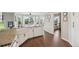 Bright kitchen with an island sink, white cabinets, hardwood floors, and natural light enhancing the cooking experience at 9385 Prairie View Dr, Highlands Ranch, CO 80126
