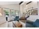 Bright living room with large windows, hardwood floors, and comfortable seating creating an inviting and airy space at 9385 Prairie View Dr, Highlands Ranch, CO 80126