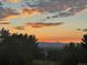 Scenic sunset view over mountains and trees, highlighting the beautiful natural surroundings at 9385 Prairie View Dr, Highlands Ranch, CO 80126