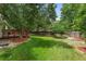Expansive backyard featuring a green lawn, mature trees, a wooden deck, and a hammock at 11313 Haswell Dr, Parker, CO 80134