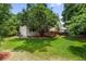 Lush green backyard with mature trees and a deck, offering a private and serene outdoor space at 11313 Haswell Dr, Parker, CO 80134