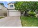 Charming two-story home featuring a brick-accented facade, mature tree, and a well-maintained front lawn at 11313 Haswell Dr, Parker, CO 80134