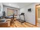 A well-lit home office with hardwood floors, a large desk, and a treadmill for exercise at 11313 Haswell Dr, Parker, CO 80134