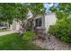 Landscaped side yard with gravel, bushes and green grass surrounding the house's siding and window at 11313 Haswell Dr, Parker, CO 80134