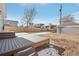 Spacious backyard with a large deck and partial snow coverage at 1835 S Lincoln St, Denver, CO 80210