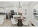 Bright dining area with a round wooden table and four white chairs, adjacent to the kitchen at 1835 S Lincoln St, Denver, CO 80210