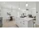 Open concept kitchen with large island and white cabinets, flows into living space at 1835 S Lincoln St, Denver, CO 80210