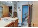 Cozy bathroom featuring a single sink vanity and views to the upper-level stairway at 10035 E Mexico Ave, Aurora, CO 80247