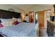 Primary bedroom with a high ceiling, dark furniture, and a patterned bedspread at 10035 E Mexico Ave, Aurora, CO 80247