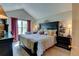 Primary bedroom with a high ceiling, dark furniture, and a patterned bedspread at 10035 E Mexico Ave, Aurora, CO 80247