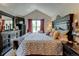 Primary bedroom with a high ceiling, dark furniture, and a patterned bedspread at 10035 E Mexico Ave, Aurora, CO 80247