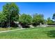 Well-manicured lawn with mature trees enhancing the lush landscape of the property at 10035 E Mexico Ave, Aurora, CO 80247