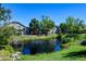 Peaceful view of a serene pond surrounded by lush greenery and beautiful townhomes at 10035 E Mexico Ave, Aurora, CO 80247