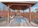 Backyard gazebo with outdoor fireplace and hanging chair, creating a cozy retreat at 767 Ellis St, Golden, CO 80401