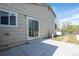An exterior view of a home's back patio with sliding glass door access to the home and path leading to the yard at 17593 E Temple Dr, Aurora, CO 80015