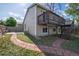 The backyard features a two-story deck and a pathway with red bricks that goes around the side of the house at 17593 E Temple Dr, Aurora, CO 80015