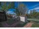 A beautiful backyard features a chicken coop, a shed for storage, a short fence and lovely landscaping at 17593 E Temple Dr, Aurora, CO 80015