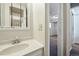 A peek into the bathroom shows a classic vanity with a bright mirror and tiled shower at 17593 E Temple Dr, Aurora, CO 80015