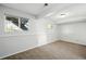 A bright carpeted bedroom with two windows offering natural light and a view of the surrounding yard at 17593 E Temple Dr, Aurora, CO 80015