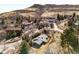 Aerial view of a home nestled near a hillside with mature trees and greenery, showcasing the surrounding landscape at 14475 Foothill Rd, Golden, CO 80401