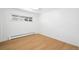 Empty bedroom with light wood floors, baseboard heating, and a window at 14475 Foothill Rd, Golden, CO 80401