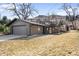 A ranch-style home with a 2-car garage, well-maintained lawn, and a stone-accented exterior at 14475 Foothill Rd, Golden, CO 80401