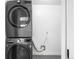 Modern laundry room with stacked washer and dryer, and tiled flooring at 14475 Foothill Rd, Golden, CO 80401