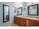 Bathroom featuring double sinks, granite countertop and a large mirror at 1285 Spinnaker Trl, Monument, CO 80132