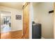 Hallway with barn door leading to the laundry room with a grey washer at 1285 Spinnaker Trl, Monument, CO 80132