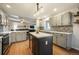 Open concept kitchen with an island, stainless appliances, mosaic backsplash, and hardwood flooring at 1285 Spinnaker Trl, Monument, CO 80132
