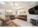 Spacious living room features a ceiling fan, leather furniture, and open access to the dining area at 1285 Spinnaker Trl, Monument, CO 80132