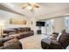 Cozy living room features a ceiling fan, leather furniture, and access to an outdoor patio at 1285 Spinnaker Trl, Monument, CO 80132