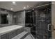 Contemporary bathroom showcasing a soaking tub and glass-enclosed shower with dark tile at 180 N Cook St # 509, Denver, CO 80206
