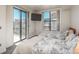 Bright bedroom featuring two beds, a sliding glass door to a balcony, and city views at 180 N Cook St # 509, Denver, CO 80206
