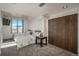 Bright bedroom with two beds, city views from the window, and a closet with dark wood doors at 180 N Cook St # 509, Denver, CO 80206