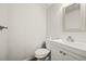 Compact powder room with a toilet, pedestal sink, and neutral finishes at 10349 W Fair Ave # A, Littleton, CO 80127