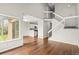 Bright living room featuring hardwood floors, staircase, and an open layout to the kitchen at 10349 W Fair Ave # A, Littleton, CO 80127
