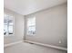 Well-lit bedroom with carpet, base trim, and two windows offering natural light and exterior views at 3976 Breakcamp Ct, Castle Rock, CO 80108