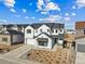 A charming two-story home features white siding, black accents, a two-car garage, and a beautifully landscaped front yard at 3976 Breakcamp Ct, Castle Rock, CO 80108