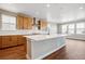 Modern kitchen features stainless steel appliances, ample wood cabinetry and a large island with white countertops at 3976 Breakcamp Ct, Castle Rock, CO 80108