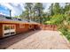 Large backyard with gravel surface leads to a raised deck, offering a beautiful outdoor space for relaxing and entertaining at 7284 Willa Ln, Evergreen, CO 80439