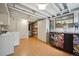 Finished basement with laminate flooring, storage, laundry and bar area with quirky sticker-covered refrigerator at 7284 Willa Ln, Evergreen, CO 80439
