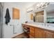 Bright bathroom featuring a single sink vanity, wood trim and shower at 7284 Willa Ln, Evergreen, CO 80439