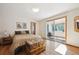 Inviting bedroom with a trunk, wood floors, and access to a sunroom at 7284 Willa Ln, Evergreen, CO 80439