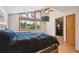 Comfortable bedroom featuring large window, ceiling fan, wood floors and spacious closet at 7284 Willa Ln, Evergreen, CO 80439